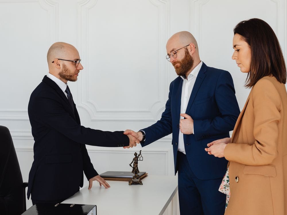 Poignée de main lors d’un premier rendez-vous, en présence d’un couple