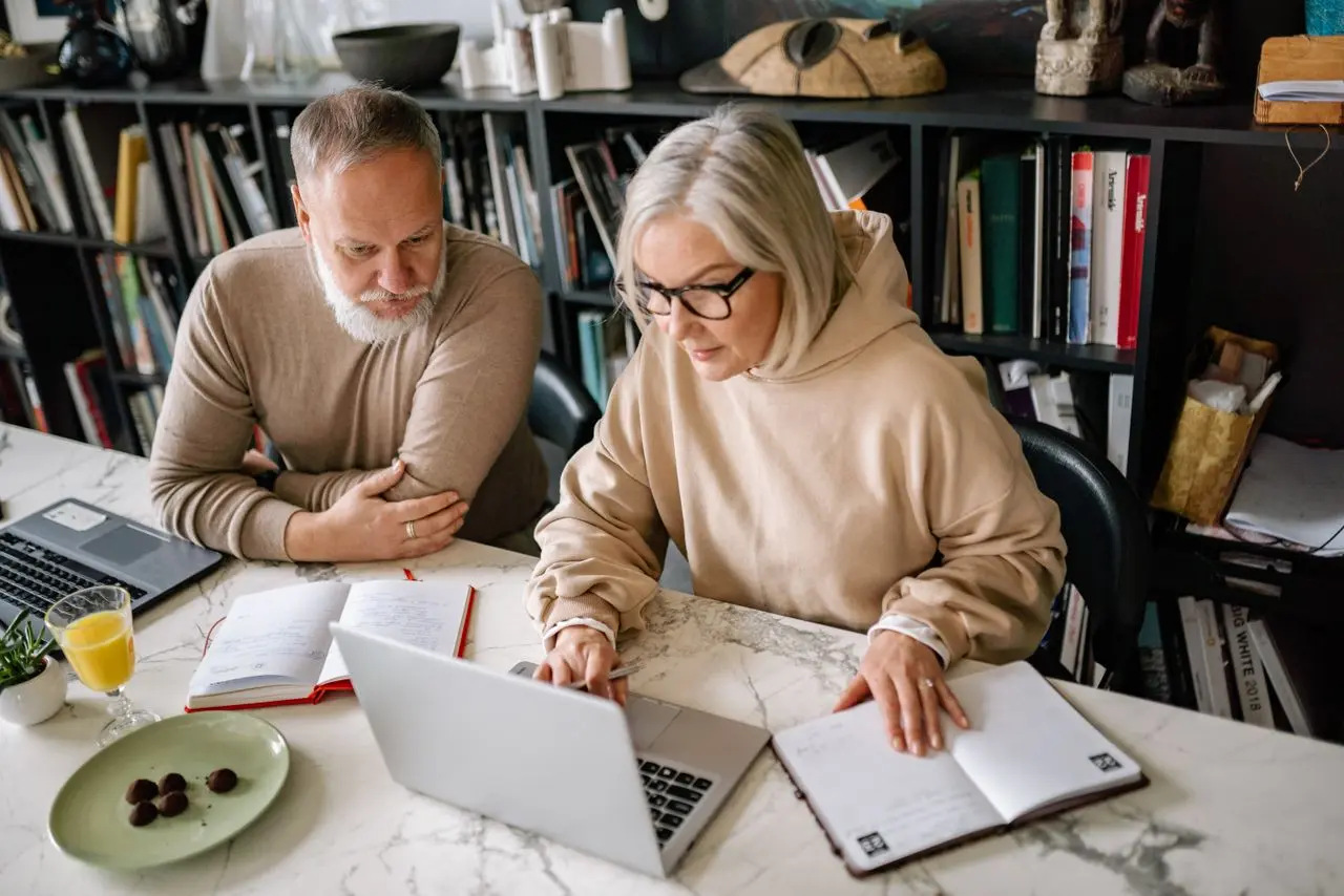 Un couple prépare ses projets devant un ordinateur portable