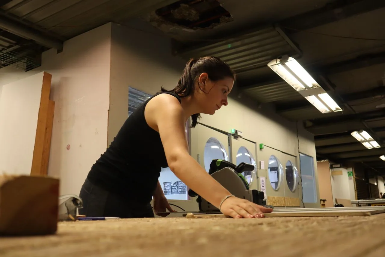 Une artisane au travail dans un atelier de menuiserie