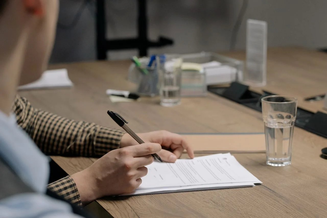 Une personne compare deux contrats sur une table