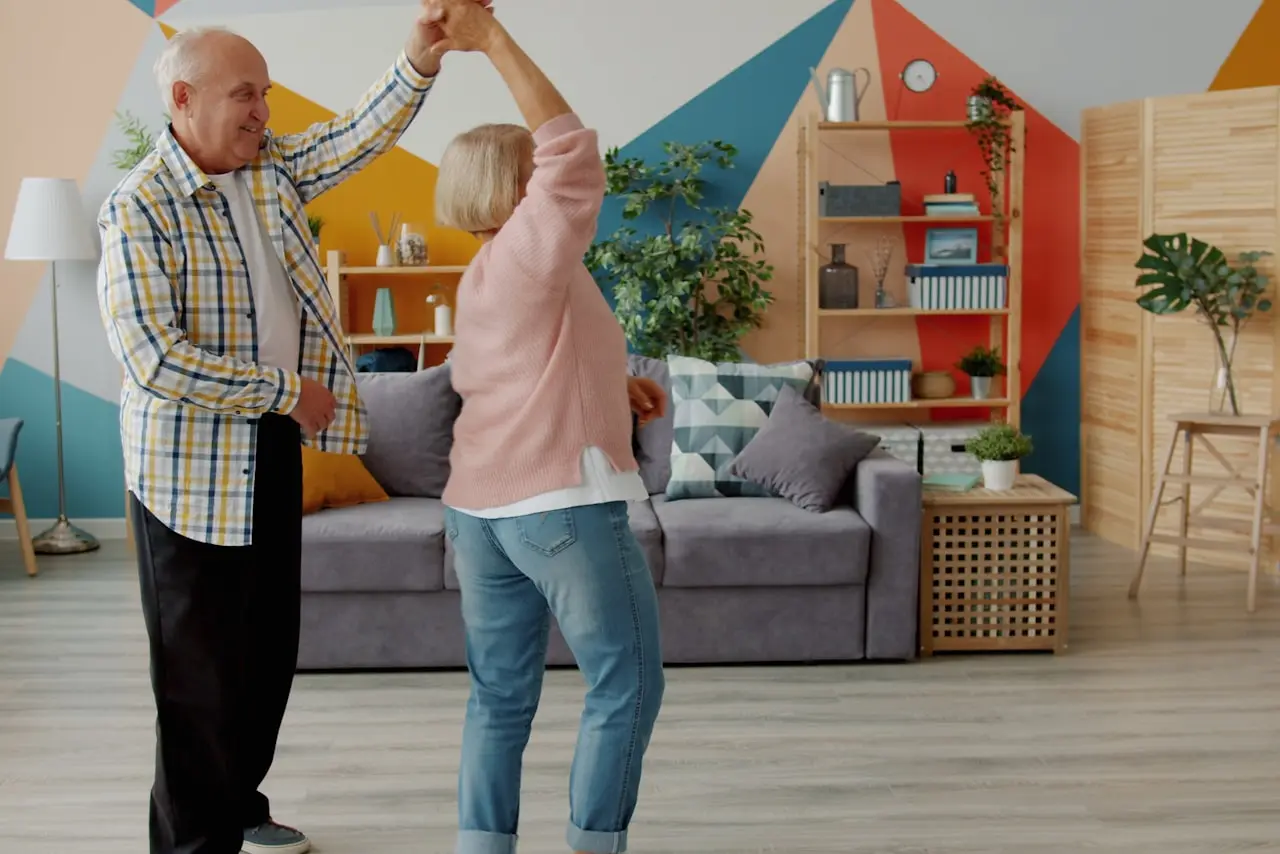 Un couple de retraités danse dans son salon