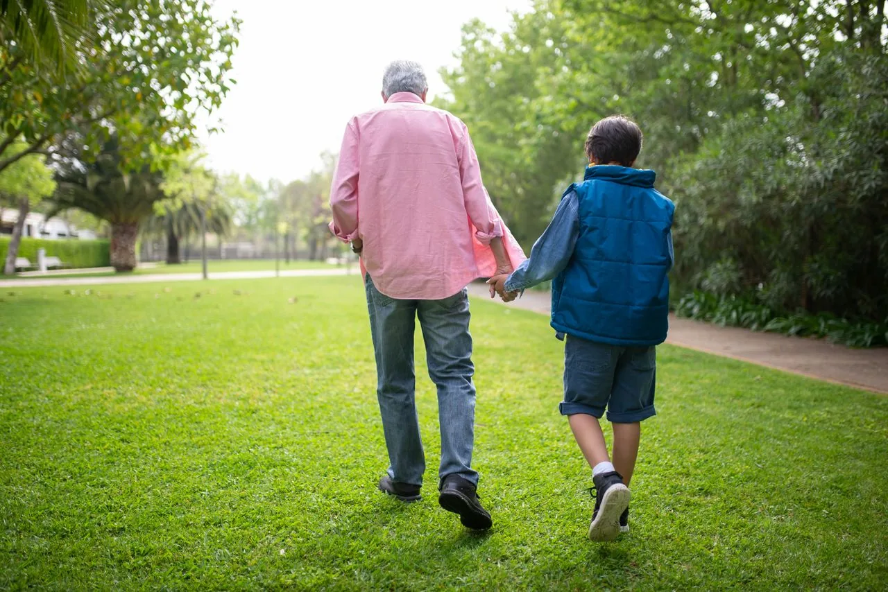 Un adulte et un enfant marchent main dans la main